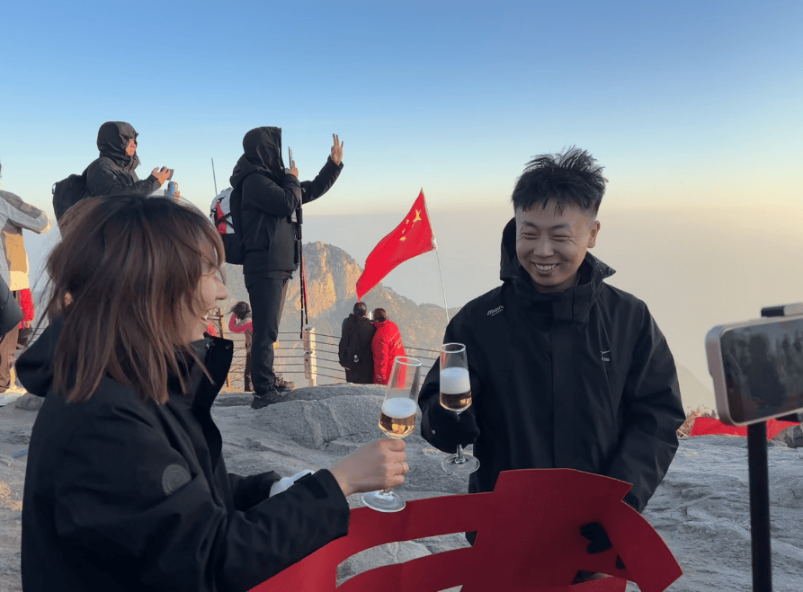 山东小伙在泰山山顶求婚,路人送上高脚杯和酒:普通求婚升华了